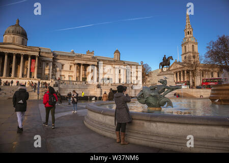 Touristen auf dem Trafalgar Square, der National Gallery, mit Bronze Statue von König George IV und St Martin-in-the-Fields Kirche an der Rückseite Stockfoto