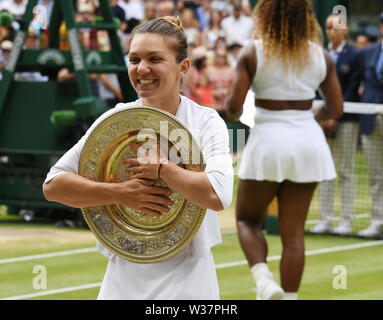 London, Großbritannien. 13. Juli, 2019. Die Meisterschaften in Wimbledon 2019 13072019 Simona Halep Umarmungen Siegertrophäe der Venus rosewater Dish nachdem Sie gewinnt Damen Singles Final, und Ihre geschlagenen Gegner Serena Williams lässt Center Court. Credit: Roger Parker/Alamy leben Nachrichten Stockfoto