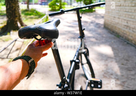 Das Fahrrad auf den Ständer. Der Radfahrer passt die zurück Reflektor Stockfoto