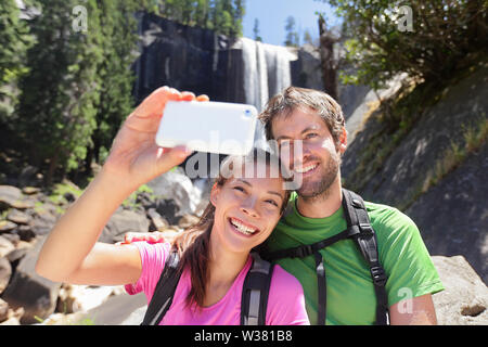 Aktiver Lebensstil paar Wanderer Wandern im Yosemite National Park, ein Selbstporträt Bild mit Smartphone von Wasserfall, Vernal Falls. Die jungen Wandern paar entspannende im Sommer Natur Landschaft. Stockfoto