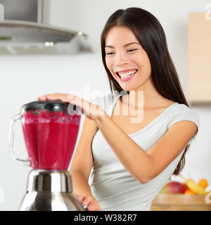 Smoothie Frau blending gesunde Rüben - Fruchtsaft. Asiatische junge Erwachsene mit Home Appliance Küche-mixer vegan Bio Gemüse Smoothie mit rohen Zutaten für Ernährung zu machen. Stockfoto