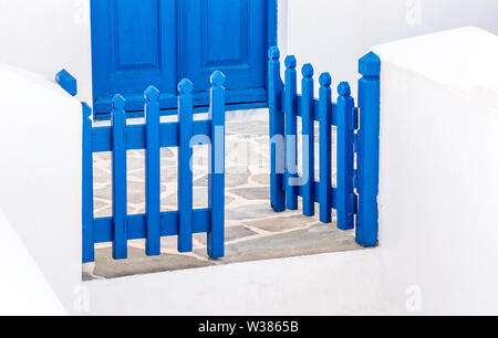 Blau Holz- Tor und Tür in einem traditionellen griechischen Kykladen Haus in eine griechische Insel in der Ägäis an einem schönen, heißen Sommertag während der Ferien Stockfoto