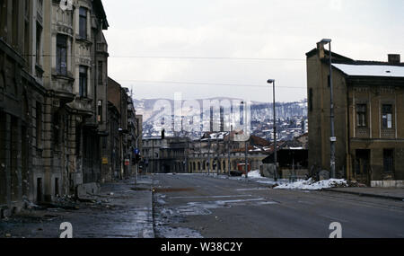 2. April 1993 während der Belagerung von Sarajevo: eine Landschaft von Ausgebrannten und zerstörten Gebäude entlang Hiseta Straße, die in die Sehenswürdigkeiten der Sniper ist. Die Hülle eines ausgebrannten Auto liegt auf dem Dach auf dem Bürgersteig. Stockfoto