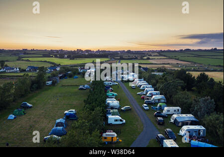 Besetzt Campingplatz bei Sonnenuntergang in Isle of Anglesey in Wales, Großbritannien Stockfoto