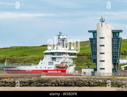 Ostensjo Rederi Norwegain Schiff Edda Sun verlassen Hafen Aberdeen mit Versand control tower, Schottland, Großbritannien Stockfoto