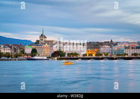 Shuttle Boot auf den Genfer See und die Aussicht auf die Innenstadt von Genf. St. Peter Kathedrale und Mont Saleve im Hintergrund. Stockfoto