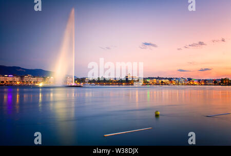 Schönen Sonnenuntergang am Genfer See. Blick auf den berühmten Brunnen, genannt Jet'Eau und die Innenstadt von Genf Stockfoto