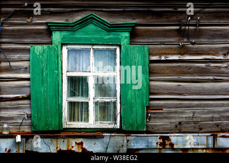 Fenster mit der aus Holz geschnitzte Architrav im alten Holz- Haus in der alten russischen Stadt. Stockfoto