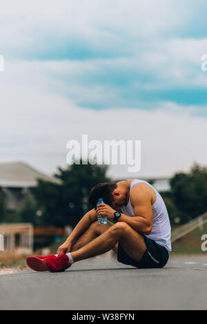 Gesund athletischer Mann mit fit, Body holding Flasche erfrischendes Wasser Stockfoto