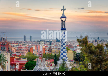 Auf Barcelona vom Park Güell auf den Sonnenuntergang. Im Vordergrund, Detail der bunten Dach der Haupteingang Gebäude. Barcelona, Spanien. Stockfoto