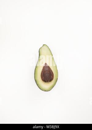 Natürliche schöne Tapete mit einer isolierten geschnitten Avocado auf einem Leuchtender rosa Hintergrund Stockfoto
