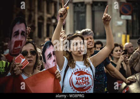 Barcelona, Spanien. 13. Juli, 2019. Ein menschenrechtsaktivist Shouts Slogans wie er marschiert durch Barcelona über die Lage der Migranten, das Mittelmeer Credit: Matthias Oesterle/Alamy Leben Nachrichten zu protestieren Stockfoto