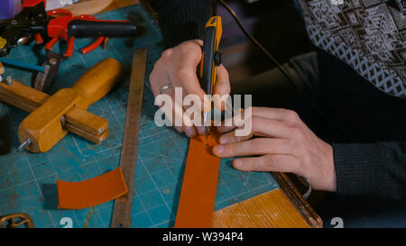 Skinner arbeiten mit Leder Gürtel Stockfoto