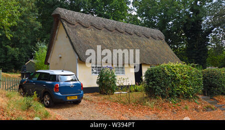 Traditionelle Reetdachhaus mit Mini Motor Auto geparkt außerhalb Stockfoto