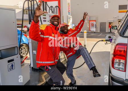 Zwei Filling station attendants Tanzen beim Auffüllen von Auto, Otjiwarongo, Namibia Stockfoto