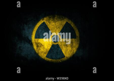 Atomenergie Radioaktivität (ionisierende Strahlung) Atomic runde gelbe Symbol Form auf massiven Beton Zement Wand Textur dunklen Hintergrund gemalt. Nucl Stockfoto