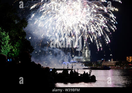 Köln, Deutschland. 13. Juli, 2019. Zuschauer verfolgen das große Feuerwerk am Rheinufer zur Musik von Jacques Offenbach als Teil der "Kölner Lichter". Quelle: Henning Kaiser/dpa/Alamy leben Nachrichten Stockfoto