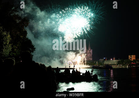 Köln, Deutschland. 13. Juli, 2019. Zuschauer verfolgen das große Feuerwerk am Rheinufer zur Musik von Jacques Offenbach als Teil der "Kölner Lichter". Quelle: Henning Kaiser/dpa/Alamy leben Nachrichten Stockfoto