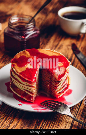 Stapel Pfannkuchen mit Beeren Marmelade auf weiße Platte über Holz- Tabelle Stockfoto