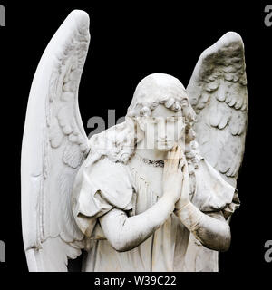Schutzengel Skulptur mit offenen Flügeln auf schwarzem Hintergrund isoliert. Engel traurigen Gesichtsausdruck Skulptur mit Augen und Händen gemeinsam vor Ch Stockfoto