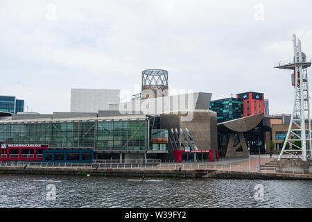 Manchester, Großbritannien - 24 April 2019: Menschen Rudern auf dem Manchester Canal mit modernen architektonischen Gebäude im Hintergrund an den Salfor Stockfoto
