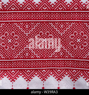 Detail der gestickten Ornament mit roten Fäden auf weißem Stoff, ukrainische Folk Stickerei, aus der Nähe. Nationale Kleidung der Ukraine Stockfoto