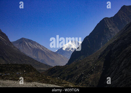 Die erste Ansicht der Tsergo Ri aus Langtang Tal mit schneebedeckten Bergen in den fernen Horizont und schwarzer Stein Berge. Stockfoto