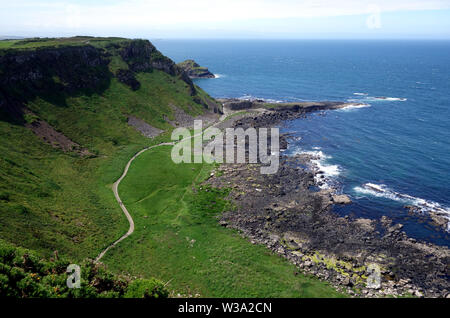 Mit Blick auf die Besucher auf dem Shepard Weg zum Damm des Riesen von der Küste weg, County Antrim, Nordirland, Großbritannien. Stockfoto