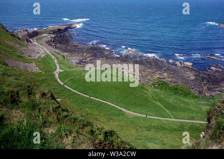 Mit Blick auf die Besucher auf dem Shepard Weg zum Damm des Riesen von der Küste weg, County Antrim, Nordirland, Großbritannien. Stockfoto