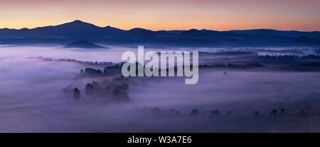 Schöner Sommer oder Herbstmorgen über dem Waldtal des Nationalparks Böhmische und Sächsische Schweiz. Nacht über dem tiefen nebligen Tal. Stockfoto
