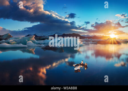 Sonnenaufgang in Jokulsarlon. isländische Eislagune von jokulsarlon am Morgen im Sommer oder Winter. Blaue Eisberge schwimmen in der Jokulsarlon Gletscherlagune Stockfoto