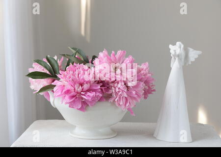 Rosa pfingstrose Blüten in einer weißen Schüssel auf einem weißen Tisch. Weißer Hintergrund. Immer noch leben. Licht am Morgen Licht im Innen weiss. Stockfoto