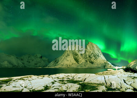 Aurora Borealis auf den Lofoten, Norwegen. Grüne Nordlichter über den Bergen. Nachthimmel mit polarem Himmel über dem arktischen Kreis. Winterlandschaft Stockfoto