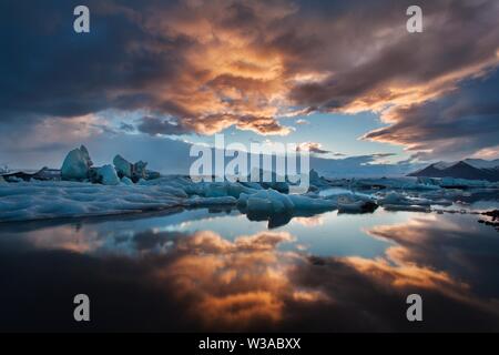 Sonnenaufgang in Jokulsarlon. isländische Eislagune von jokulsarlon am Morgen im Sommer oder Winter. Blaue Eisberge, die in der Jokulsarlon Gletscherlagune schwimmen, Stockfoto