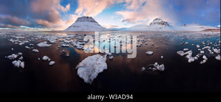 Island snaefellsnes Halbinsel und berühmten Kirkjufell im Winter Sonnenaufgang. Kirkjufell ist ein wunderschön geformter und symmetrischer Berg in Island. Gefroren Stockfoto