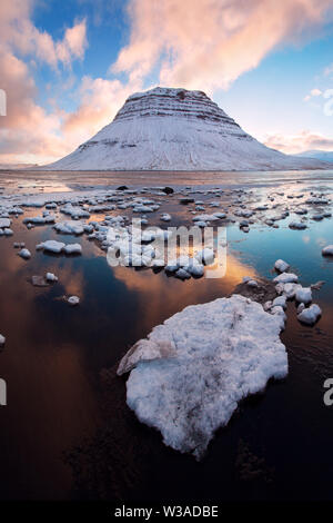 Island snaefellsnes Halbinsel und berühmten Kirkjufell im Winter Sonnenaufgang. Kirkjufell ist ein wunderschön geformter und symmetrischer Berg in Island. Gefroren Stockfoto