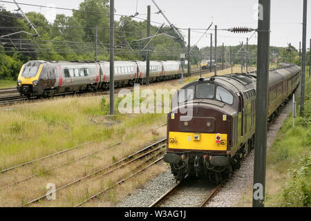 West Coast Eisenbahnen Klasse 37 Diesellok 37669 im Holgate Abstellgleise südlich von York, Großbritannien mit leeren Coaching bestand, während ein Cross Country Zug Stockfoto