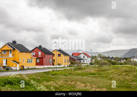 Gelbe, rote und weiße norwegische Häuser entlang der Straße in Andenes Dorf, Andoy Gemeinde, Vesteralen Bezirk, Nordland County, Norwegen Stockfoto