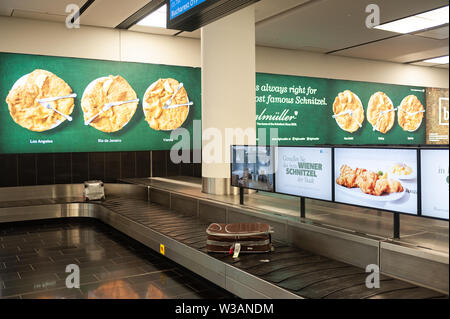 14.06.2019, Wien, Österreich, Europa - Gepäckkarussell und Werbetafeln Werbung für Wiener Schnitzel am Flughafen Wien Schwechat. Stockfoto