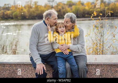 Senior Paar mit Baby Enkel im Herbst Park. Urgroßmutter, Urgroßvater und Urenkel Stockfoto