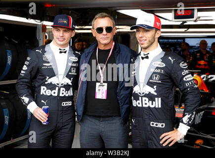 Red Bulls ' Max Verstappen (links) und Pierre Gasly (rechts) mit Daniel Craig während des Britischen Grand Prix in Silverstone, Towcester. Stockfoto