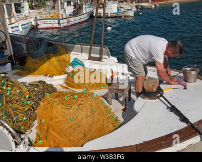 Ein Fischer arbeitet auf seinem Boot auf der griechischen Insel Serifos Stockfoto