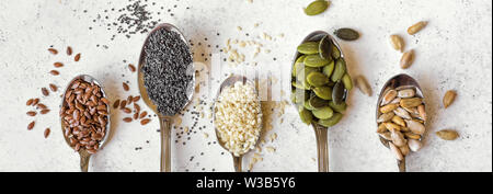Verschiedene Samen auf weißem Hintergrund. Sortiment, der Samen auf Löffeln, gesunde Inhaltsstoffe in Lebensmitteln, superfood, Ansicht von oben, Banner ist. Stockfoto