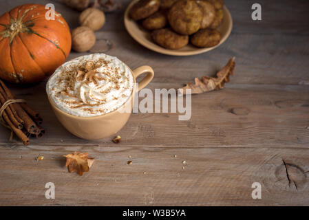 Pumpkin Spice Latte. Tasse Latte mit saisonalen Herbst Gewürze, Kekse und Fall Dekor. Traditionelle Kaffee Trinken für die Herbstferien. Stockfoto