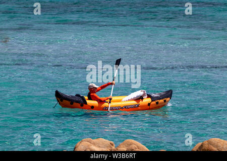 Alghero, Italien - 06.16.2019: Mann Paddeln in einem orange Sea Kayak, Schlauchboot. Sommer-/Winterzeit. Stockfoto