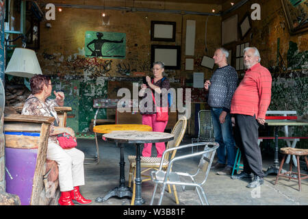 BUDAPEST, Ungarn - 09 April, 2019: Eine Gruppe älterer Touristen in coloful Kleidung selfies und Fotos mit Handys im Szimpla Kert pub ruinieren. Stockfoto