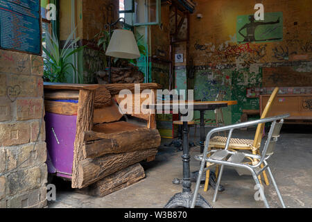 BUDAPEST, Ungarn - 09 April, 2019: Vintage Stühle und Tisch in Szimpla Kert pub Ruine, ein beliebtes Touristenziel in Budapest. Stockfoto