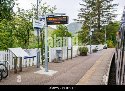 Glenfinnan ländlichen Bahnhof Plattform und den Namen Schild mit ScotRail Zug an der West Highland Railway Line, Scottish Highlands, Schottland, UK Stockfoto