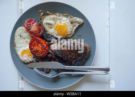 Ansicht von oben, eine Platte mit Steak und Eier und gebratenen Tomaten Stockfoto