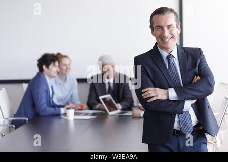 Portrait einer stattlichen Geschäftsmann vor seinem Team im Büro Stockfoto